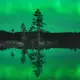 Photo d'une aurore boréale sur un lac proche d'Ivalo